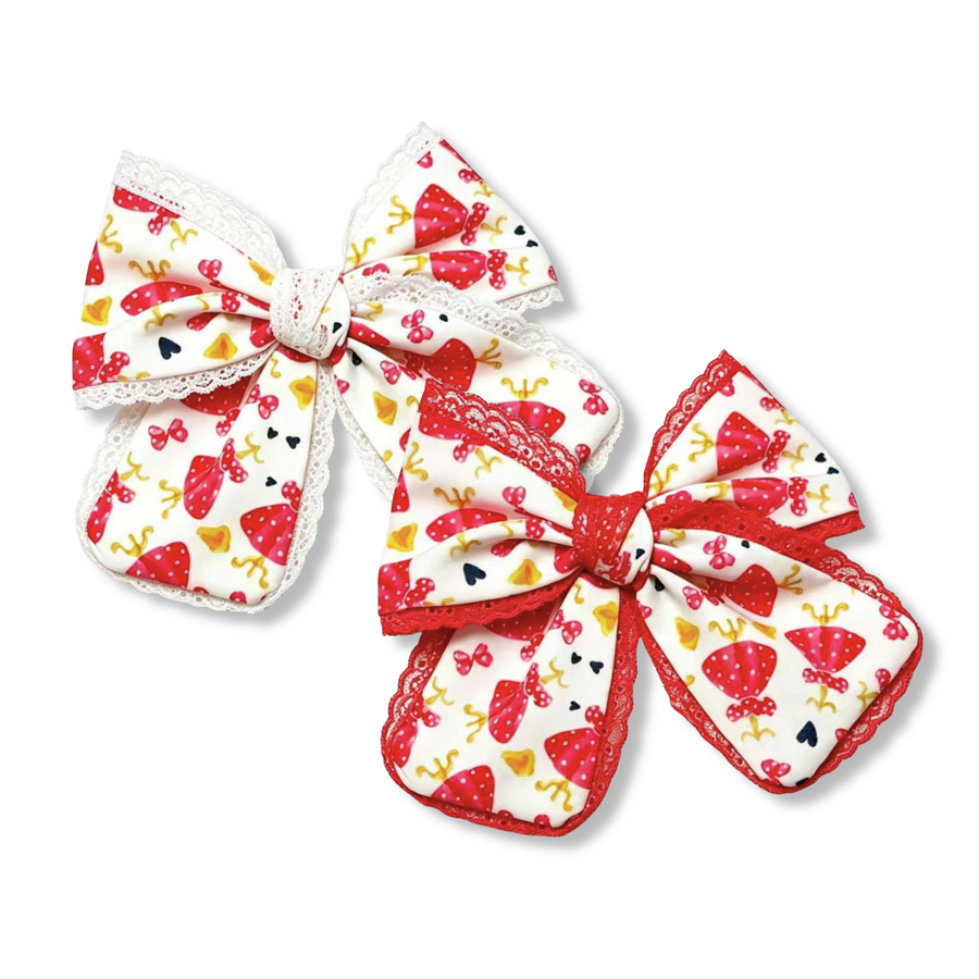 These charming boutique bows feature a white ribbon printed with red polka-dot dresses, bows, hearts, and coordinating character-inspired accents. One bow is trimmed with delicate white lace for a classic look, while the other features vibrant red lace trim for added contrast. The layered design and soft rounded loops create a sweet, timeless style perfect for themed outfits and everyday wear.
you choose red or white lace trim
Small 5" X 6"
