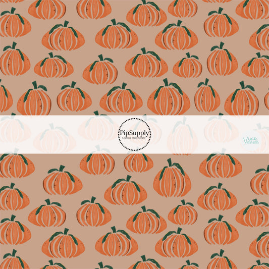 Orange pumpkins on taupe colored fabric by the yard.