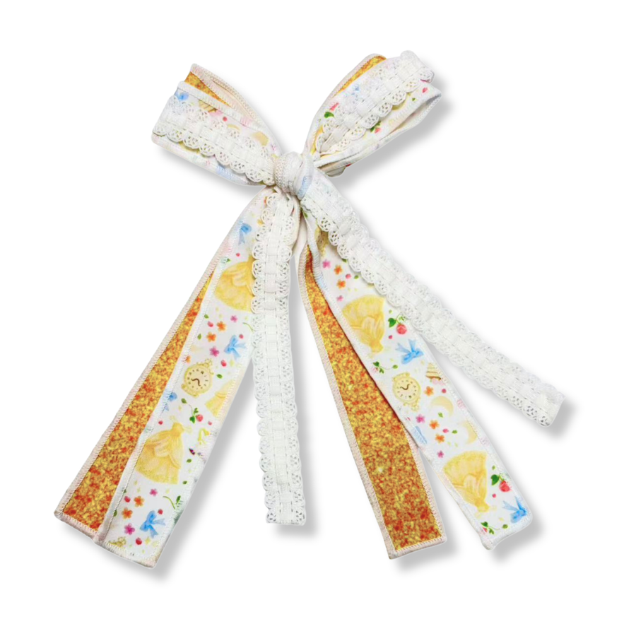 This charming three-ribbon bow features a combination of coordinating textures and prints tied together into a whimsical, elegant design. One ribbon showcases a princess-inspired print on a white background with yellow gowns, enchanted clocks, bows, flowers, and other fairytale details. A sparkling golden glitter ribbon adds shimmer and contrast, while a delicate white lace ribbon brings soft texture and vintage charm. 
Bow Sizing 4" x 8"