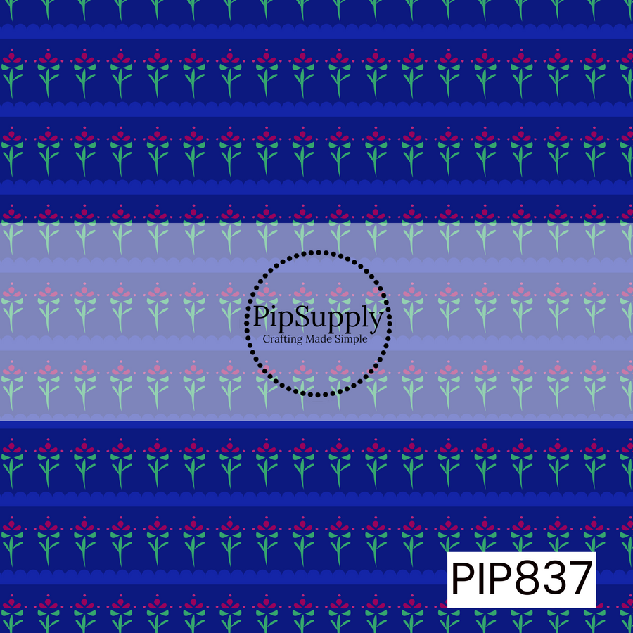 Deep cobalt blue background featuring horizontal bands of stylized folk-art flowers in bright pink and mint green. The repeating floral rows are separated by scalloped stripe accents, creating a structured border-style pattern. The simple flower motifs and bold color palette give the design a charming Scandinavian-inspired aesthetic with a clean, whimsical, and traditional folk-art feel.

