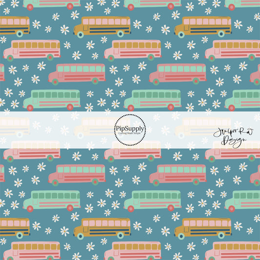 Blue fabric by the yard with pink, yellow, and aqua colored school buses and white daisies. 