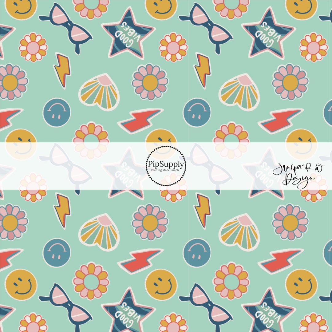 Smiley faces, glasses, lightning bolts, and flowers school themed stickers on aqua blue fabric by the yard.