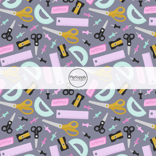 Drak grey fabric by the yard with school supplies such as scissors, erasers, and rulers.