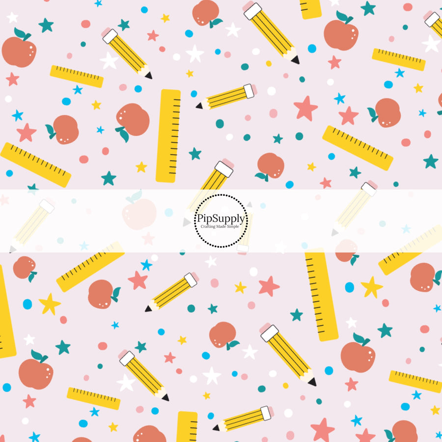 Light pink fabric by the yard with dots, stars, rulers, apples, and pencils.