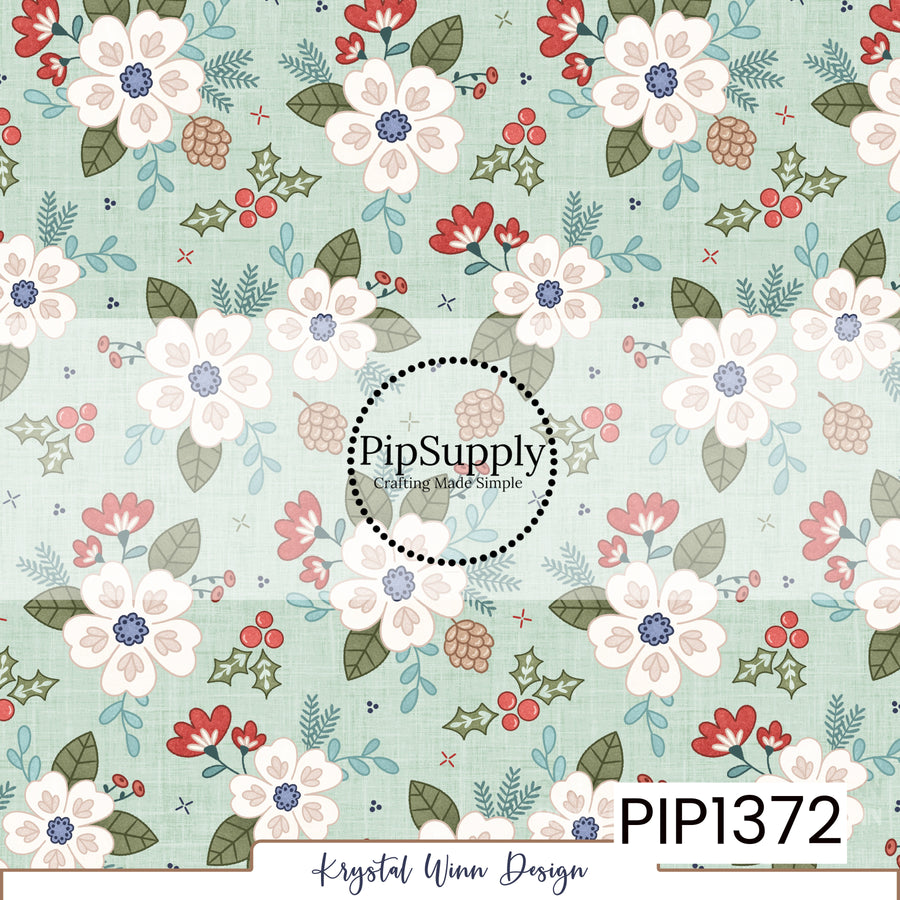 A charming winter floral print featuring large ivory flowers with soft blush petal details and dusty blue centers against a pale mint green, linen-textured background. The flowers are surrounded by muted olive green leaves, dusty teal foliage, delicate evergreen sprigs, small coral red blossoms, pinecones, and clusters of bright red holly berries. Scattered tiny accents complete this whimsical, vintage-inspired design with a soft and cozy holiday feel.