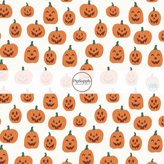 Cream fabric by the yard with orange smiling jack-o-lanterns.