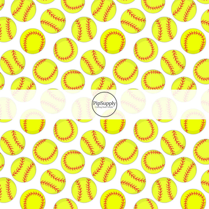 Yellow softballs with red stitching on white fabric by the yard.