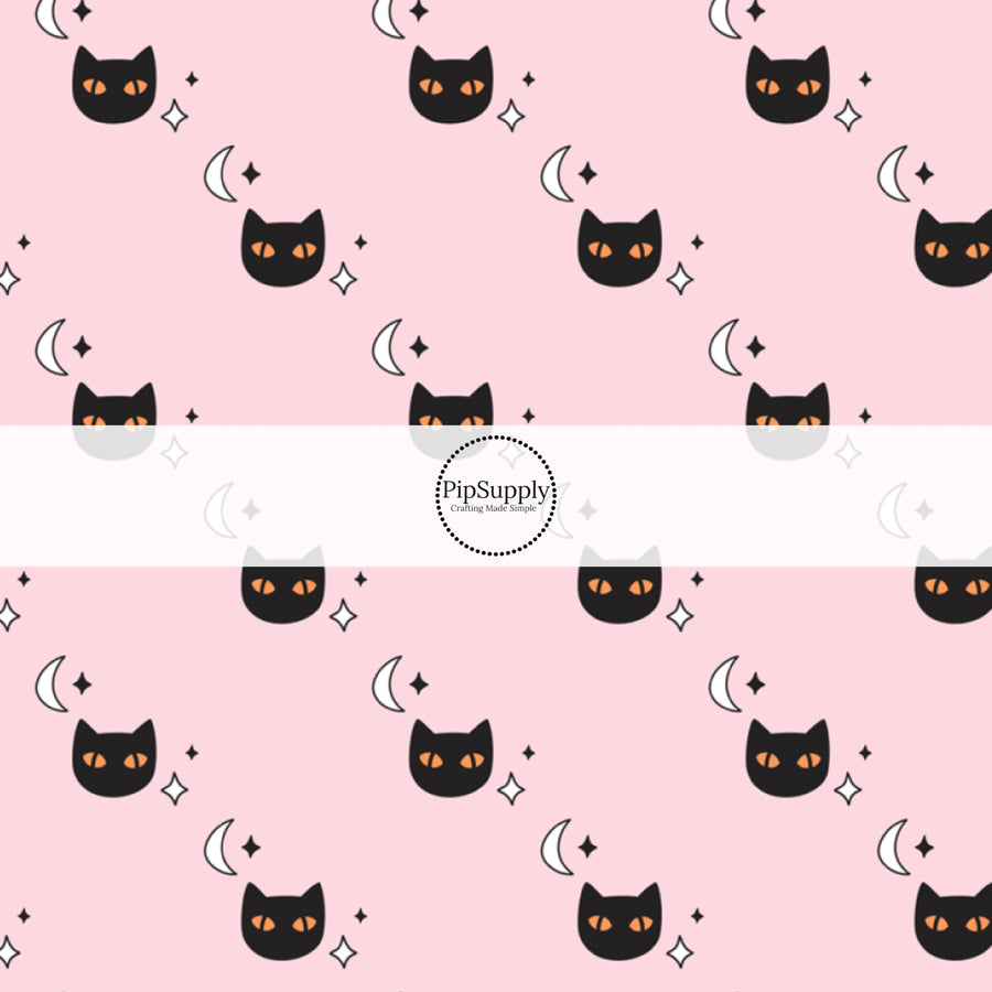 Black cats with orange eyes, moons, and stars, on pink fabric by the yard.