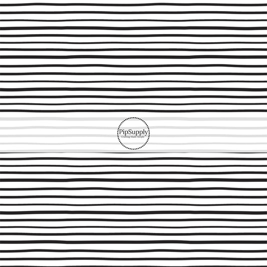 Thin black stripes on white fabric by the yard.
