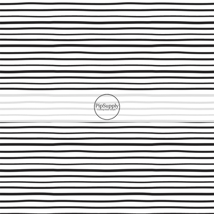 Thin black stripes on white fabric by the yard.