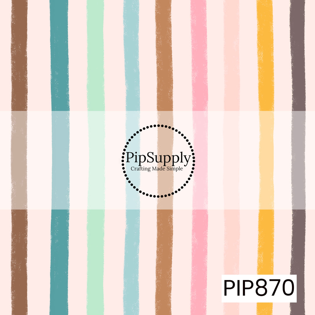 A soft watercolor stripe pattern featuring vertical brushstroke lines in tan, teal, mint green, light aqua, caramel brown, blush pink, pale peach, golden yellow, and charcoal gray on a light pink background. The textured, hand-painted stripes create a relaxed and artistic feel, while the muted rainbow palette adds warmth and charm.
