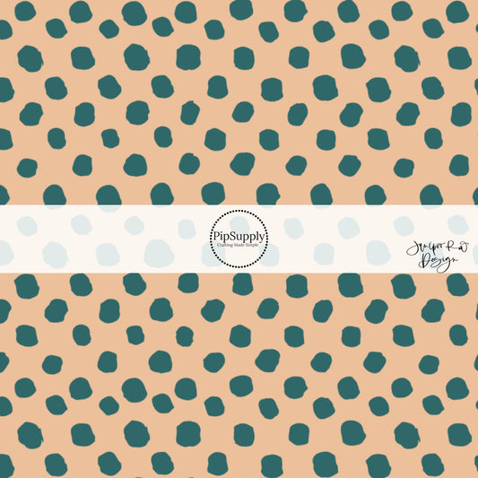 Teal blue speckled dots on cream fabric by the yard.