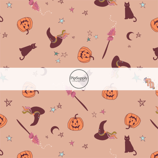 Witch hats, cats, pumpkins, stars, and broomsticks on dark nude fabric by the yard.