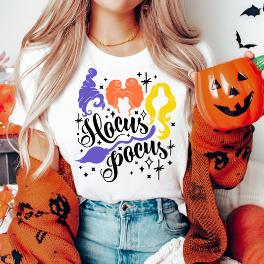 Iron on heat transfer with three witches and the phrase "Hocus Pocus" in black font.