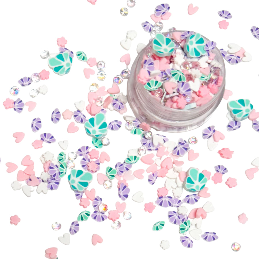 These Mermaid Shells Clay slices are versatile for many festive craft projects. These clays are shaped as&nbsp; mermaid shell purple and green, clear rhinestones, and pink heart designed clay slices. You can use it to add sparkle and decoration to resin projects, filling for shaker bows, slime making, party decor, scrapbooking, card making and nail art.