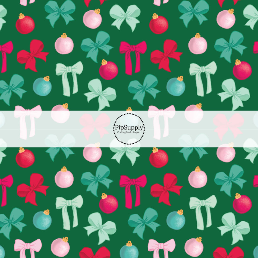 green and pink bows and ornaments on dark green fabric by the yard