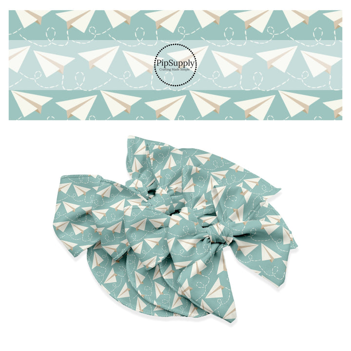 Cream paper airplanes with tails on blue hair bow strips