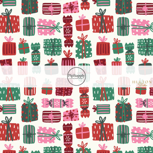 These Christmas themed pattern fabric by the yard features the following design elements: red, green, and pink wrapped presents on cream. This fun themed fabric can be used for all your sewing and crafting needs!