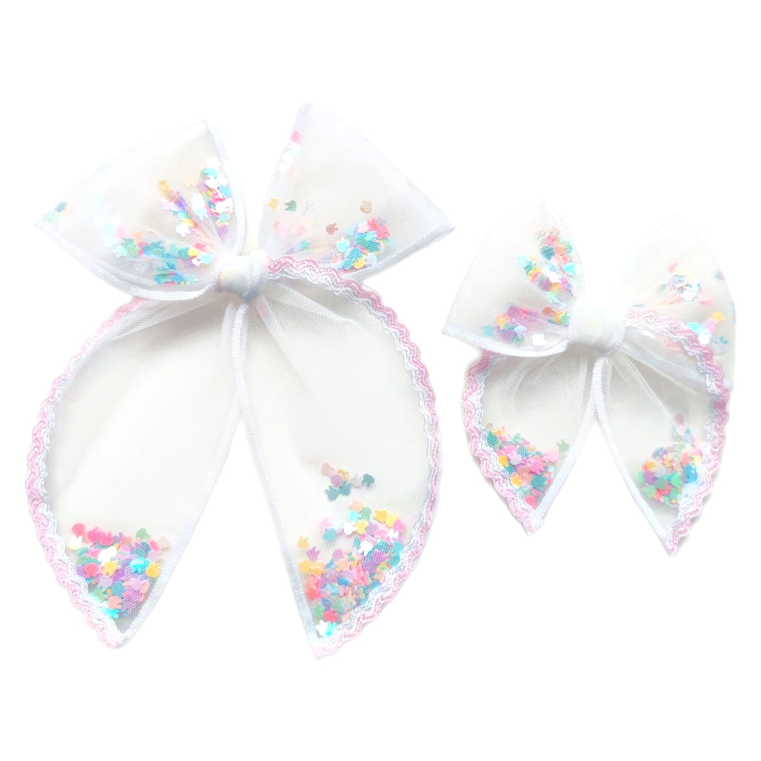 These spring light pink ric rac white tulle pre-cut shaker tied bows are ready to package and resell to your customers no sewing or measuring necessary! These hair bows come with a alligator clip already attached and come filled with colorful Easter bunnies.