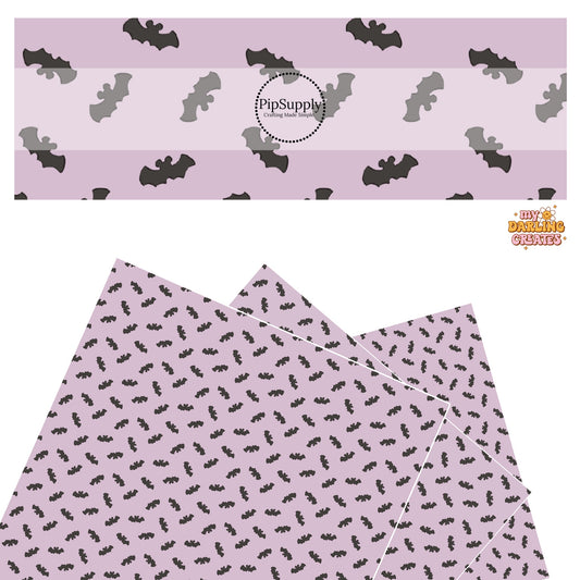 Black bat with mouse ears on lilac faux leather sheets