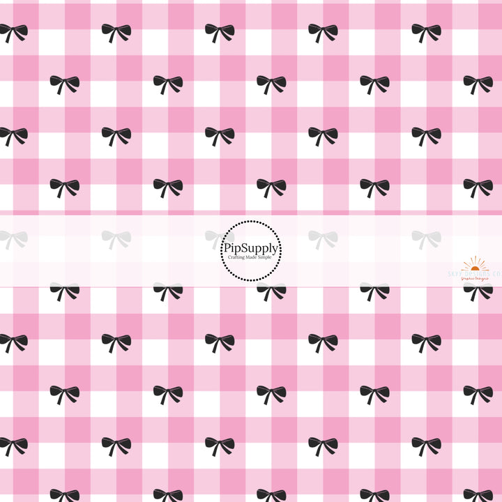 This holiday fabric by the yard features pink plaid and black bows. This festive pattern fabric can be used for all your sewing and crafting needs!