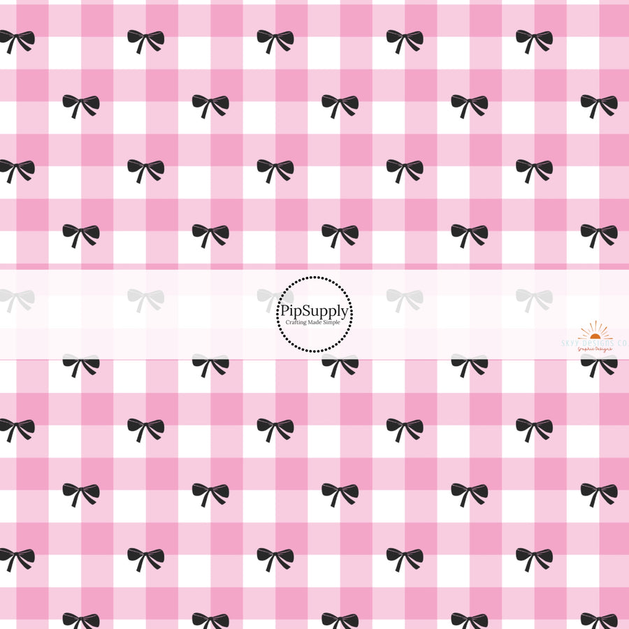 This holiday fabric by the yard features pink plaid and black bows. This festive pattern fabric can be used for all your sewing and crafting needs!