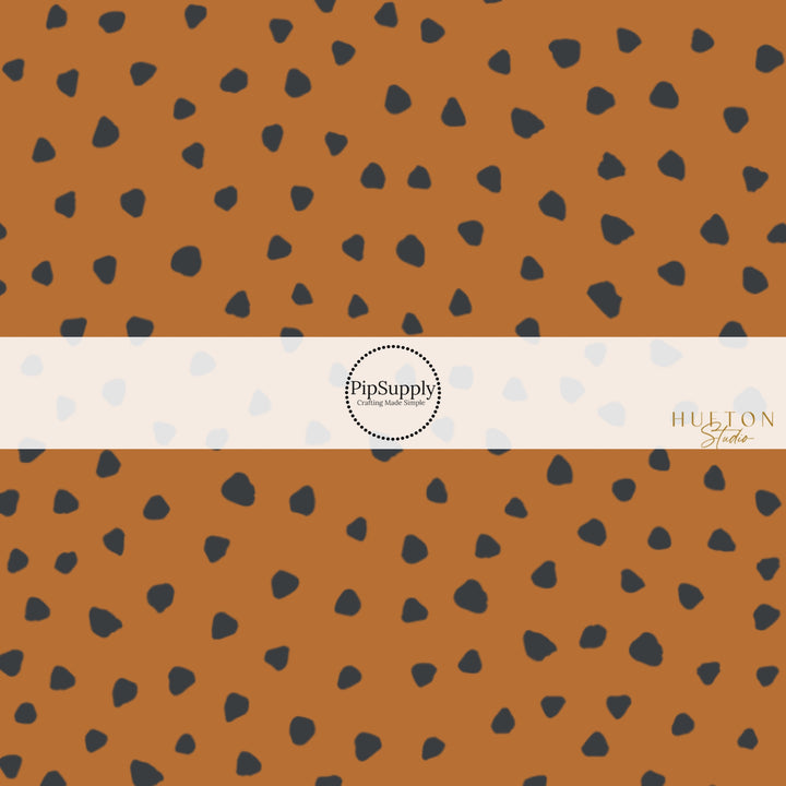 These speckled themed fabric by the yard features small black speckled dots on brown. This fun dotted themed fabric can be used for all your sewing and crafting needs! 