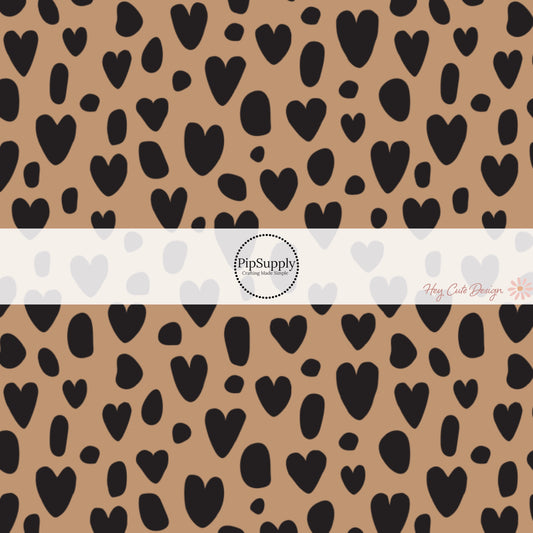 These heart and spot themed brown fabric by the yard features leopard pattern with hearts and spots in black on brown. This fun animal themed fabric can be used for all your sewing and crafting needs! 