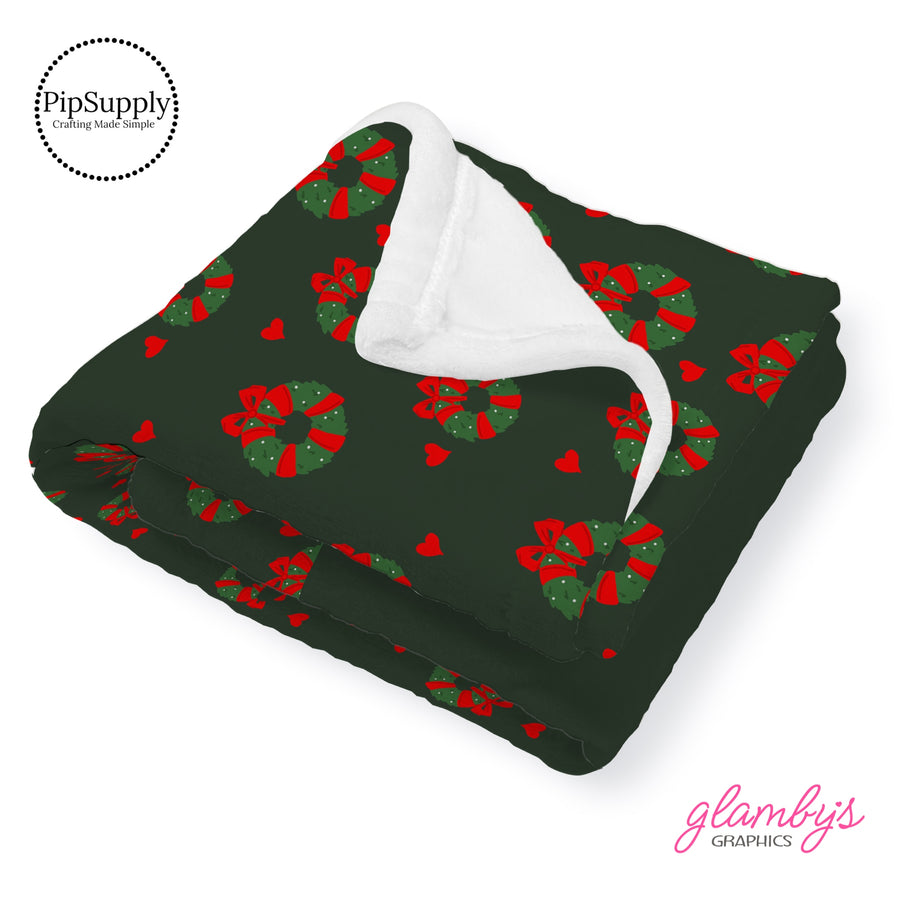 This Christmas designer pattern is printed onto the front side of our soft touch minky blankets. The backside will not be printed and left the natural cream/white color of the blanket. This print pattern features holiday wreaths with red bows on green.