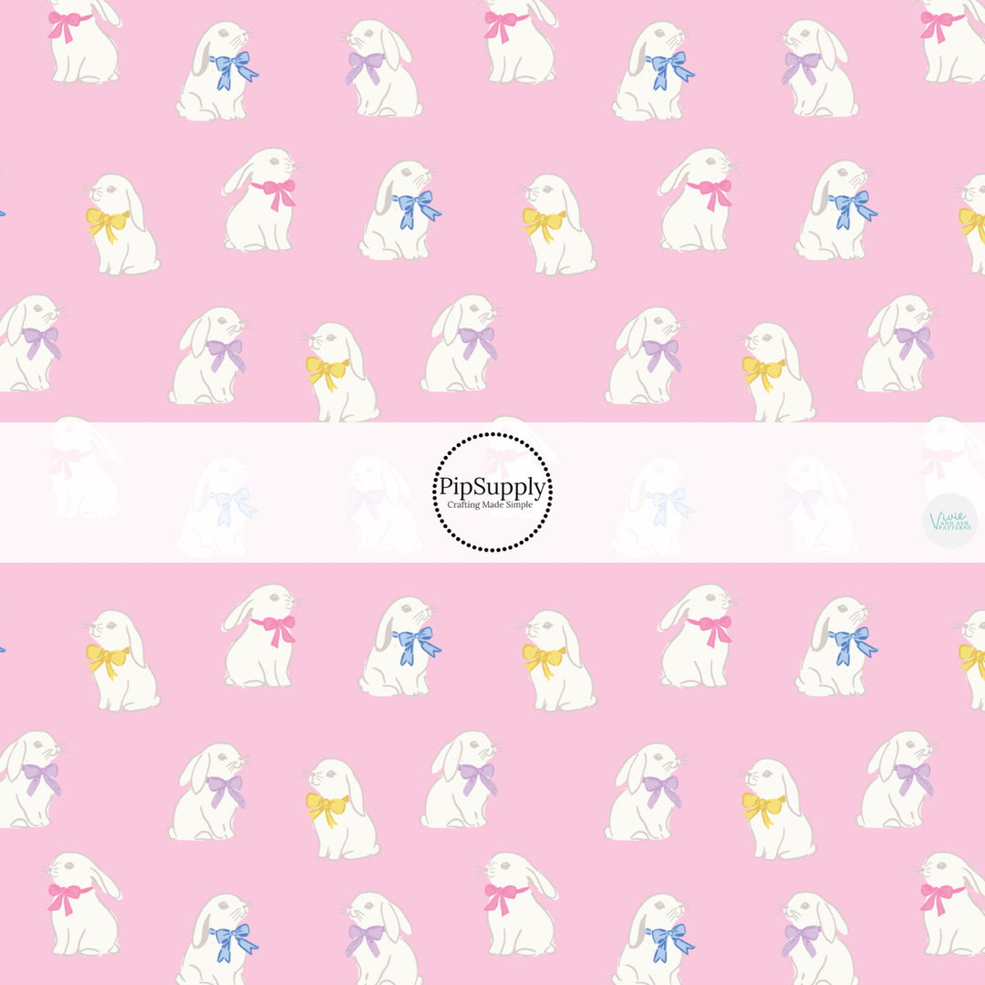 This Easter themed fabric by the yard features white bunnies with colorful bows on pink. This fun pattern fabric can be used for all your sewing and crafting needs!