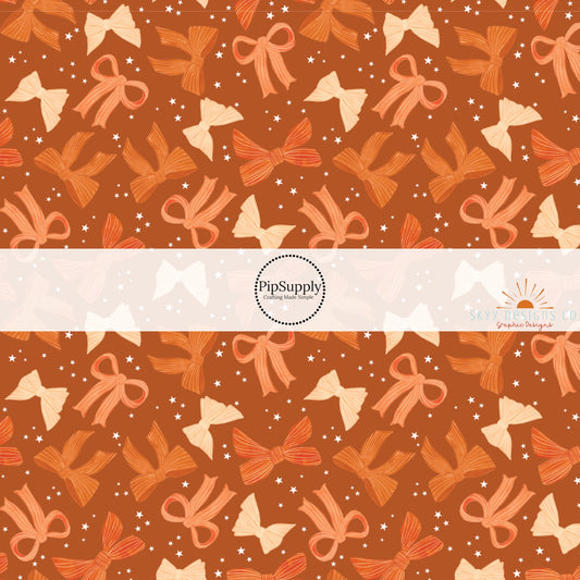 These autumn themed pattern fabric by the yard features the following design elements: colorful fall bows on orange. This fun themed fabric can be used for all your sewing and crafting needs!