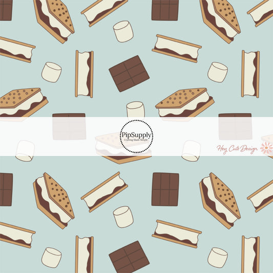 These camping smores white fabric by the yard features chocolate, graham crackers, and marshmallows on light blue. This fun outdoor dessert themed fabric can be used for all your sewing and crafting needs! 