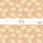 These floral themed light pink fabric by the yard features cream and orange flowers.