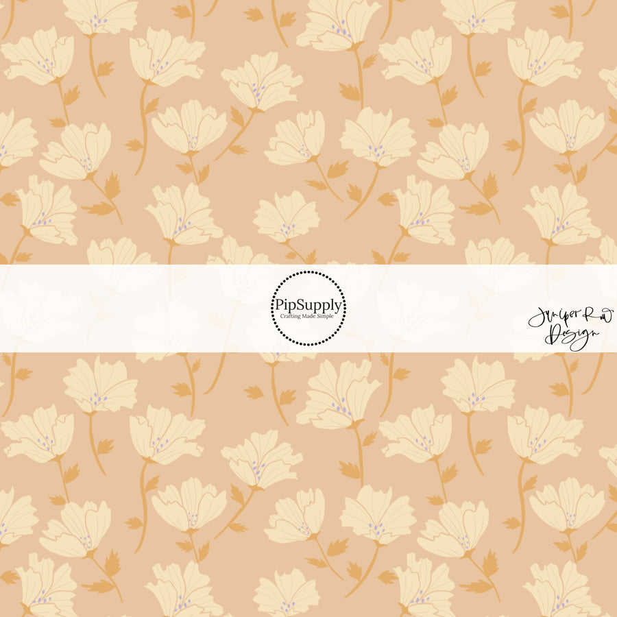 These floral themed light pink fabric by the yard features cream and orange flowers.