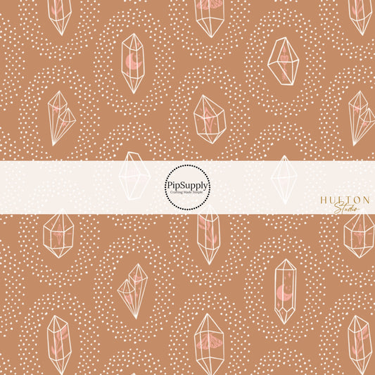 These crystal dot themed brown fabric by the yard features small white dots surrounding crystals on brown. This fun themed fabric can be used for all your sewing and crafting needs! 