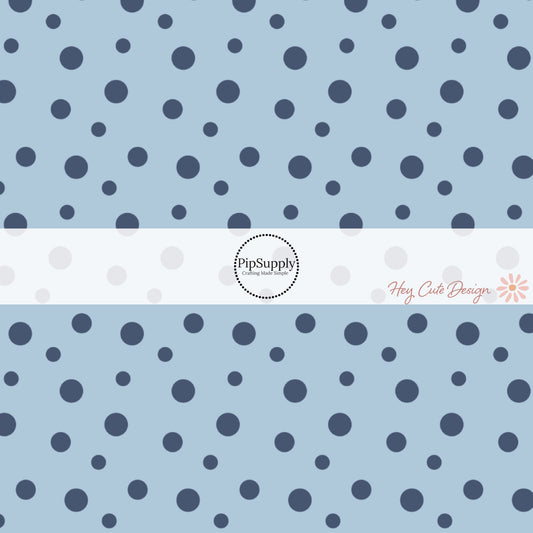 These dot themed light blue fabric by the yard features small dark navy blue dots on light blue. 