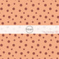 These dot themed light orange fabric by the yard features small dark orange and brown dots on light peach. 