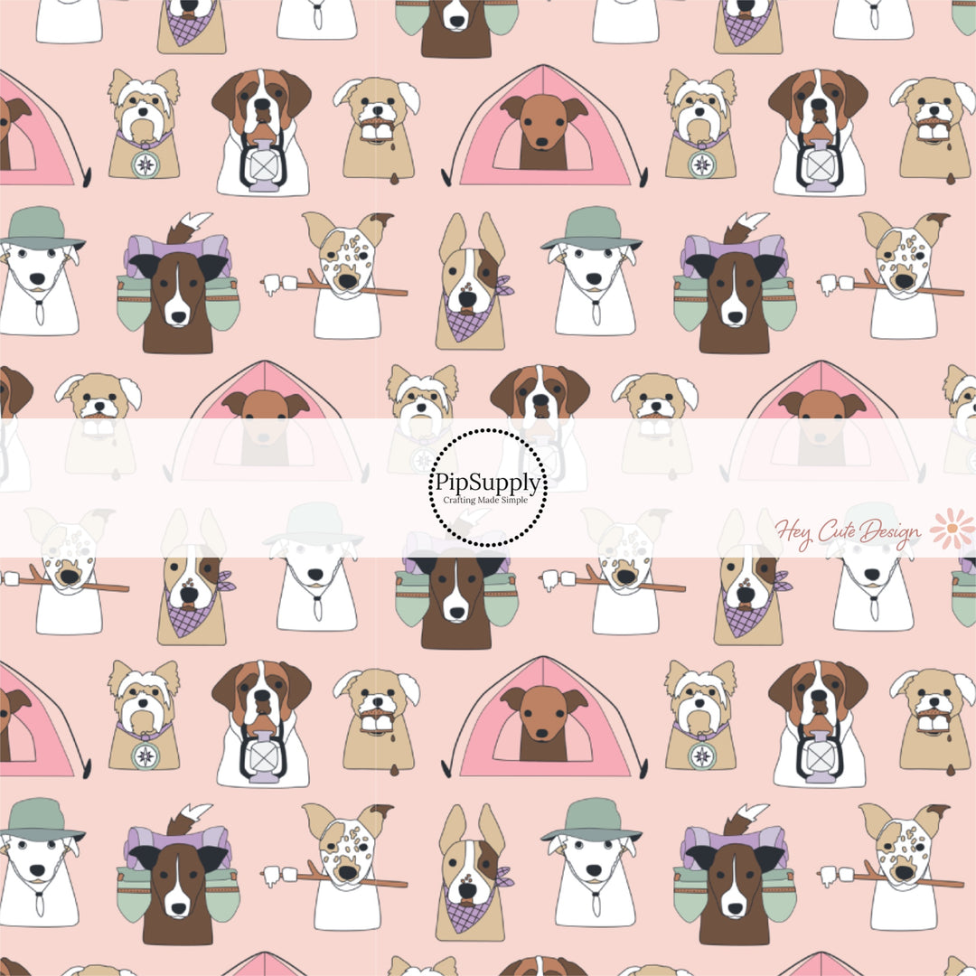 These camping dog outdoor themed light pink fabric by the yard features a variety of different dog faces with hats, smores and tents on pink. This fun animal themed fabric can be used for all your sewing and crafting needs! 