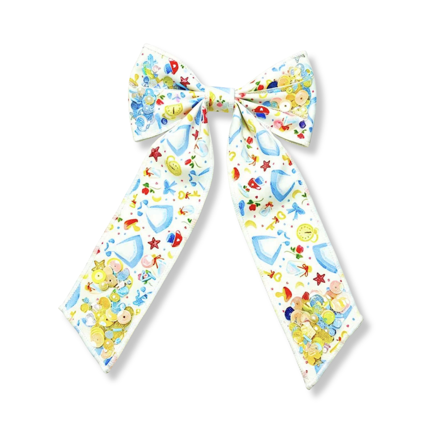 A whimsical fairytale-inspired long-tail bow featuring glass slippers, enchanted keys, clocks, and stars on a white background. Shaker pockets filled with pastel and iridescent sequins add magical sparkle and movement, making it the perfect accessory for any princess-inspired look.
Bow Sizing 5" x 8.5"