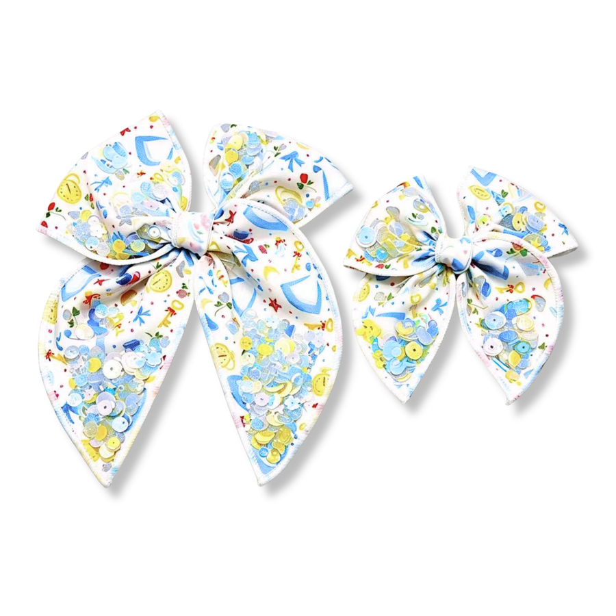 Whimsical fairytale-inspired bows featuring a charming print of glass slippers, enchanted keys, clocks, bows, and delicate florals on a white background. Each bow is accented with shaker pockets filled with pastel blue, yellow, silver, and iridescent sequins that move freely for a playful sparkle effect. The soft pastel color palette and magical details create an enchanting statement piece perfect for princess lovers and storybook-inspired styles. come in large and small 
Small 4.5" x 4.5"
Large 6.5" x 6.5"