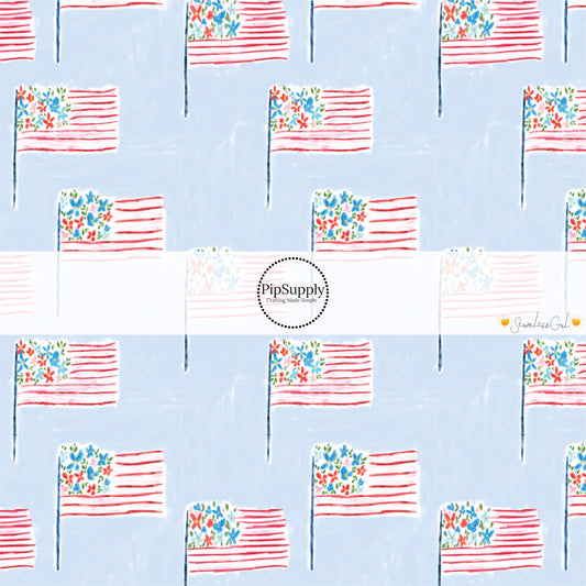 This 4th of July fabric by the yard features patterned American flags on light blue. This fun patriotic themed fabric can be used for all your sewing and crafting needs!