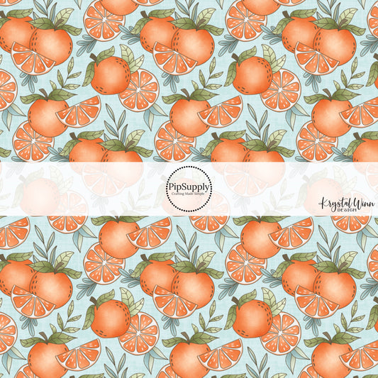 These fruit on light blue fabric by the yard features oranges and orange slices.