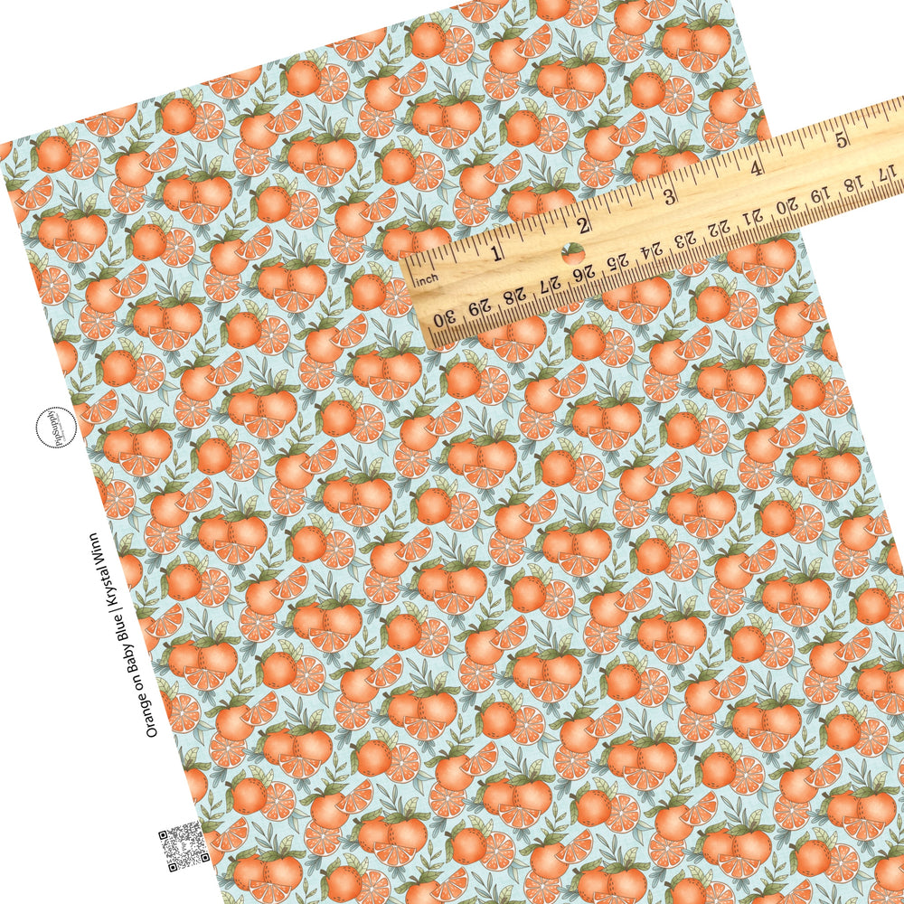 These fruit on light blue faux leather sheets contain the following design elements: oranges and orange slices.