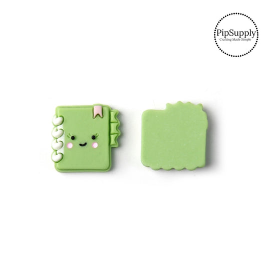 Smiley face and blushing cheeks on green notebook with pink bookmark and cream spirals flat back resin embellishment