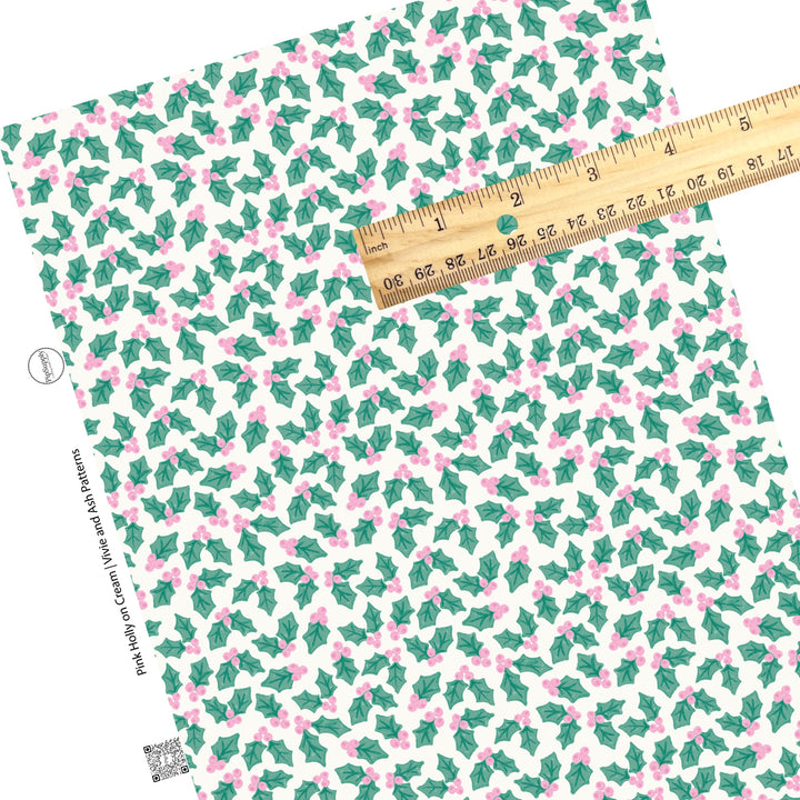 Green holly leaves and pink berries on cream faux leather sheets