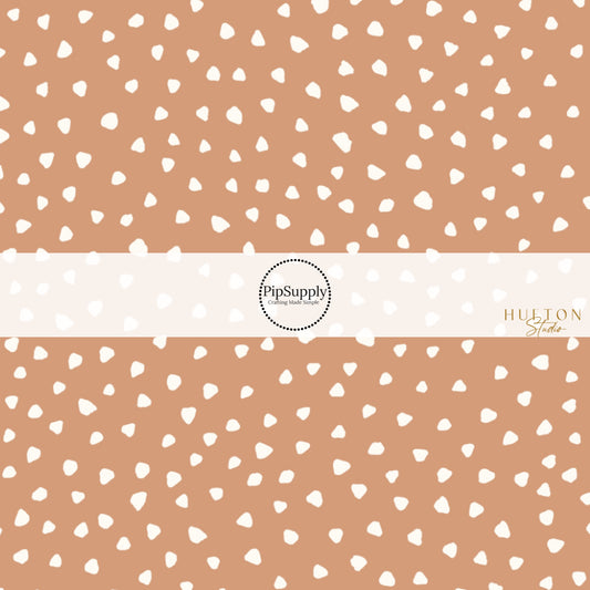 These speckled themed fabric by the yard features small cream speckled dots on tan. This fun dotted themed fabric can be used for all your sewing and crafting needs! 