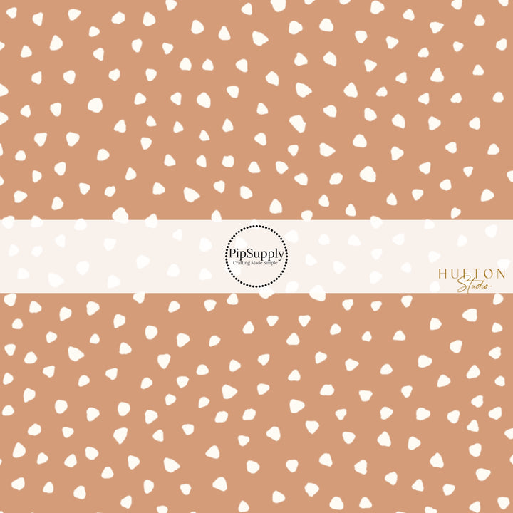 These speckled themed fabric by the yard features small cream speckled dots on tan. This fun dotted themed fabric can be used for all your sewing and crafting needs! 