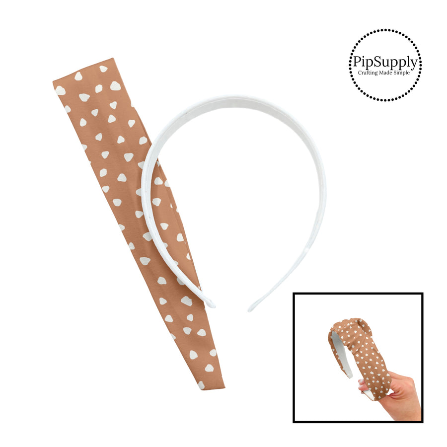 These speckled themed headband kits are easy to assemble and come with everything you need to make your own knotted headband. These kits include a custom printed and sewn fabric strip and a coordinating velvet or ribbed headband. The headband kits features small cream speckled dots on tan.