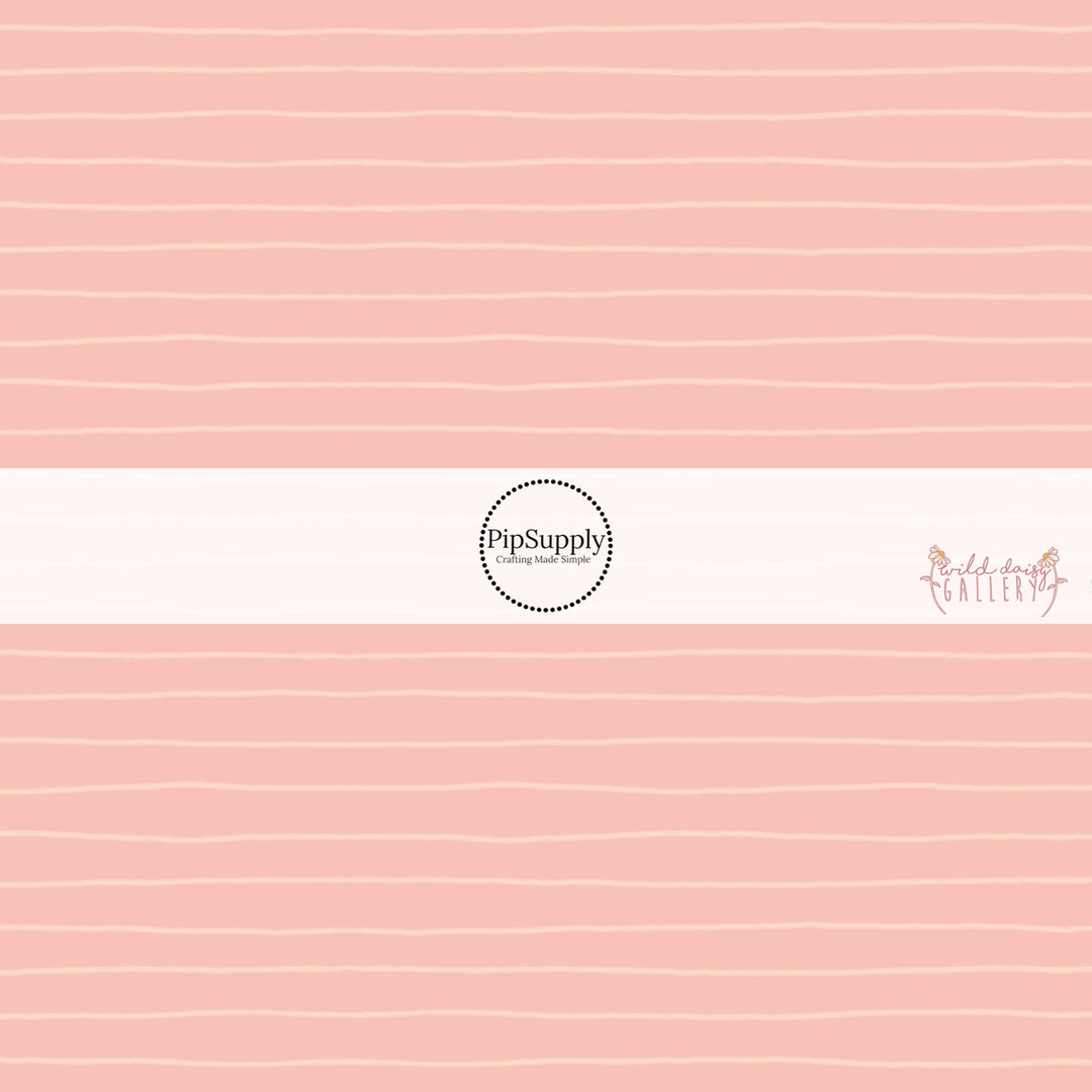 These stripe themed light pink fabric by the yard features small cream pinstripes on light peach.