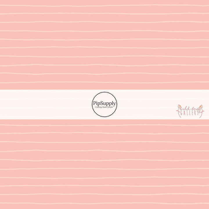 These stripe themed light pink fabric by the yard features small cream pinstripes on light peach.